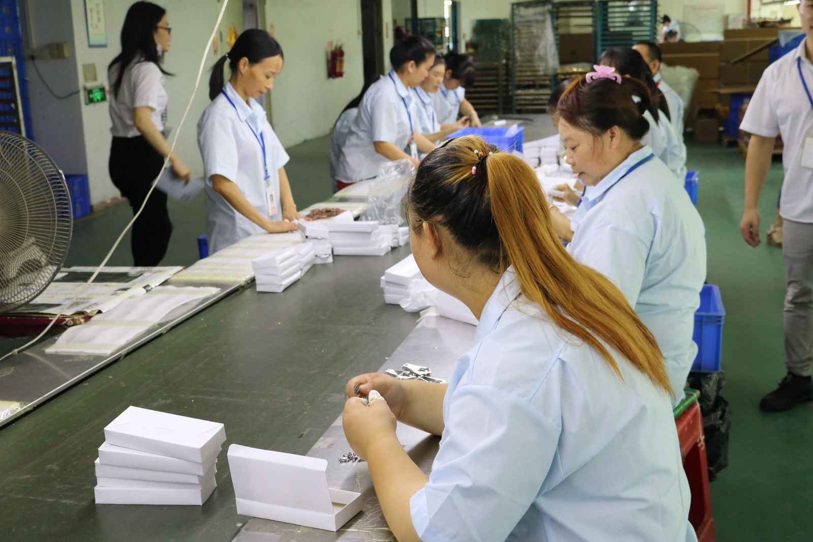 Packaging team wrapping finished metal gifts in foam and cartons for export