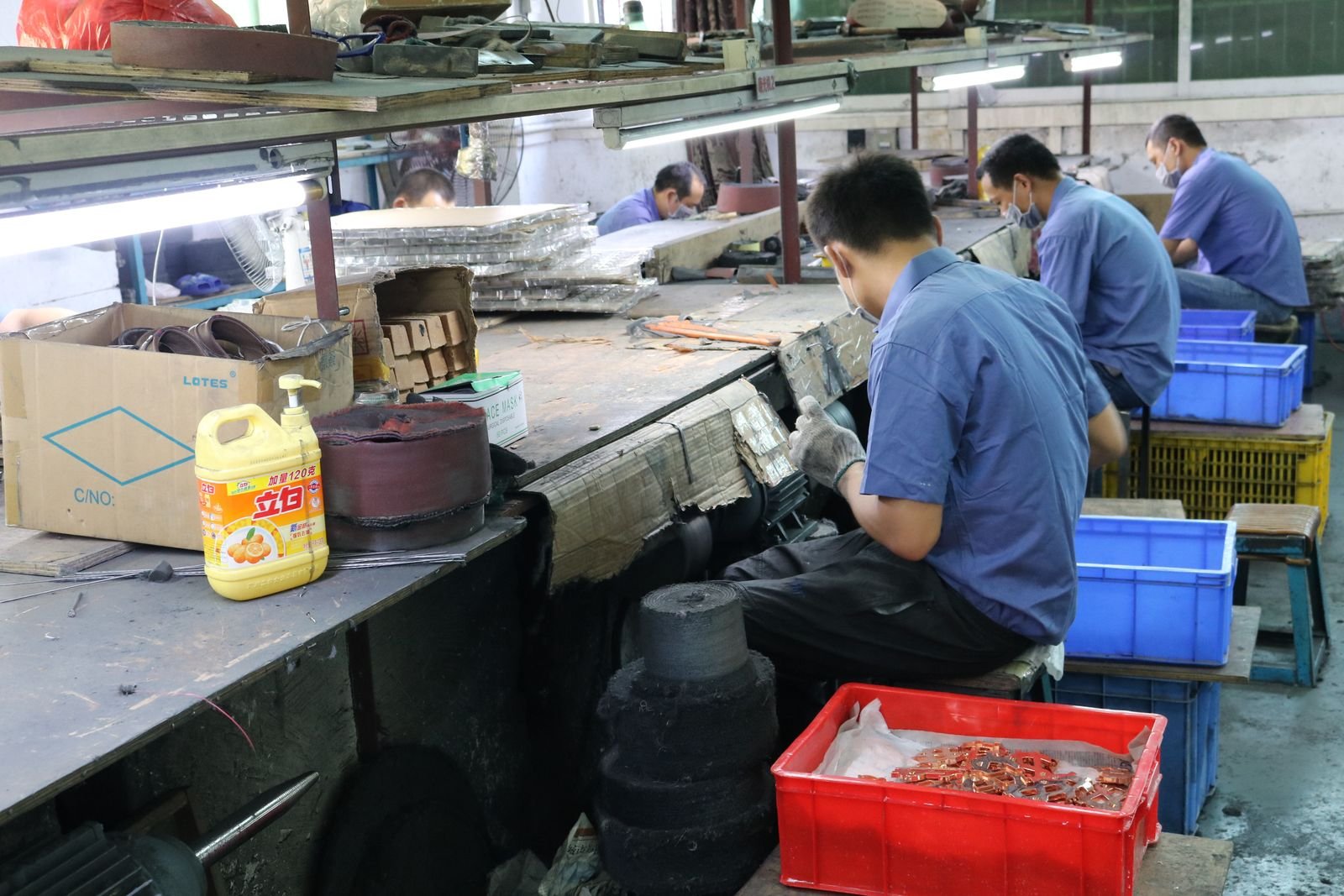 Belt sanding station polishing metal gift parts to final texture