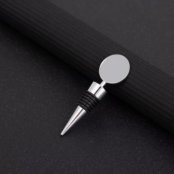 Silver wine stopper with round branded cap shown on black background